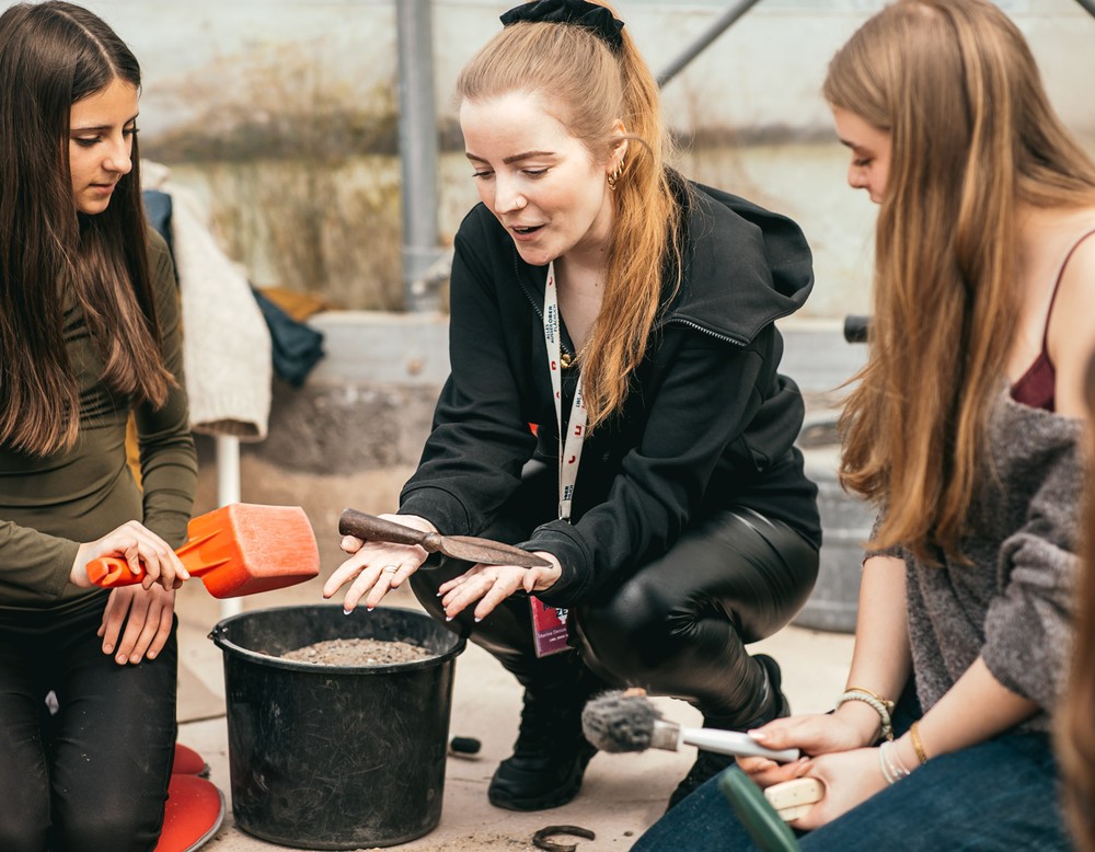 Eine Expertin bestimmt gemeinsam mit Schüler:innen den Fund.