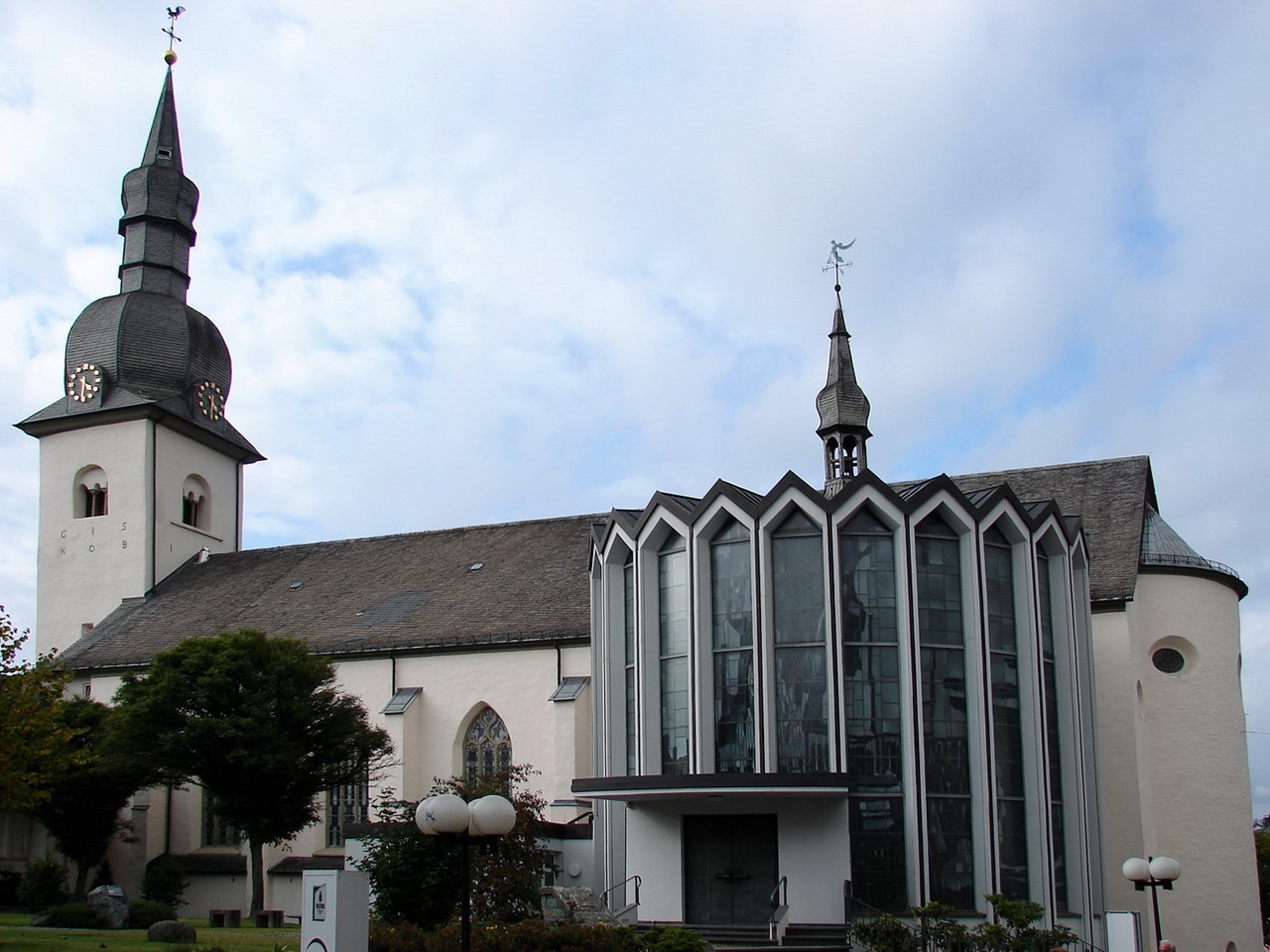 Die Hallenkirche St.Walburga, ehemals Stift Meschede, von der Seite. Der Glockenturm an der linken Seite ragt über dem Gebäude hervor.