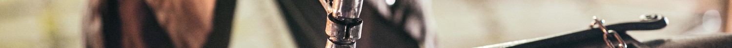 Nahaufnahme Amboss, auf dem mit einem Hammer glühendes Metall bearbeitet wird.