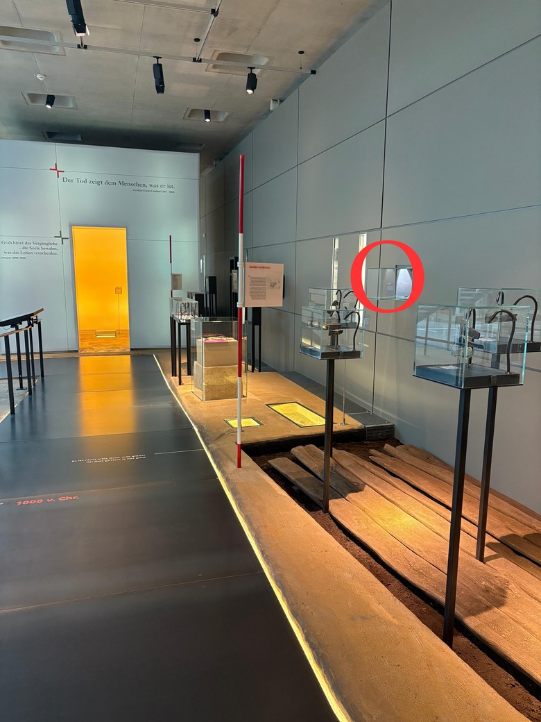 Weg des Bronzezeitbereichs in der Dauerausstellung im LWL-MAK, Der Weg ist schwarz, Vitrinen auf der rechten Seite, eine Vitrine ist rot eingekreist