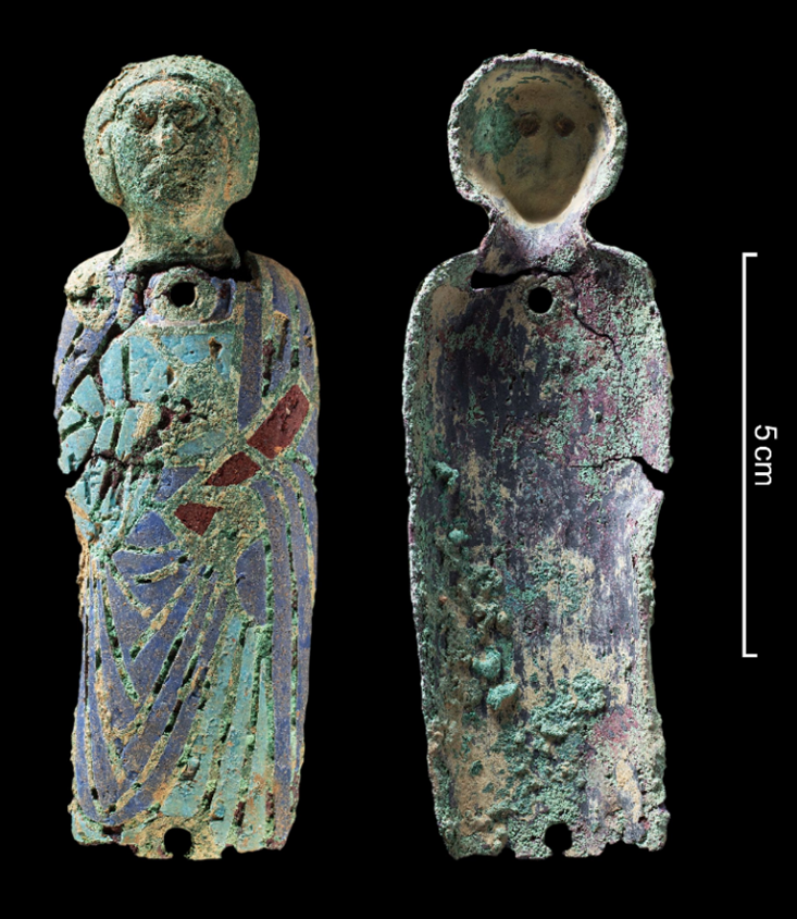 Zwei Ansichten derselben Metallfigur des Apostels Petrus vor schwarzem Hintergrund. Links ist die farbig emaillierte Vorderseite der Figur zu sehen. Rechts ist die korrodierte Rückseite zu sehen. Über dem oberen Loch, im Halsbereich sind leichte Risse zu erkennen, ebenso im Bereich des rechten Arms.