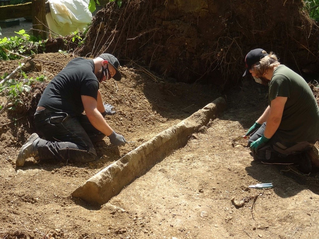 Zwei Archäologen arbeiten an einem sonnigen Tag an der Ausgrabung des Obelisken, der sich noch zum Teil in der Erde befindet.