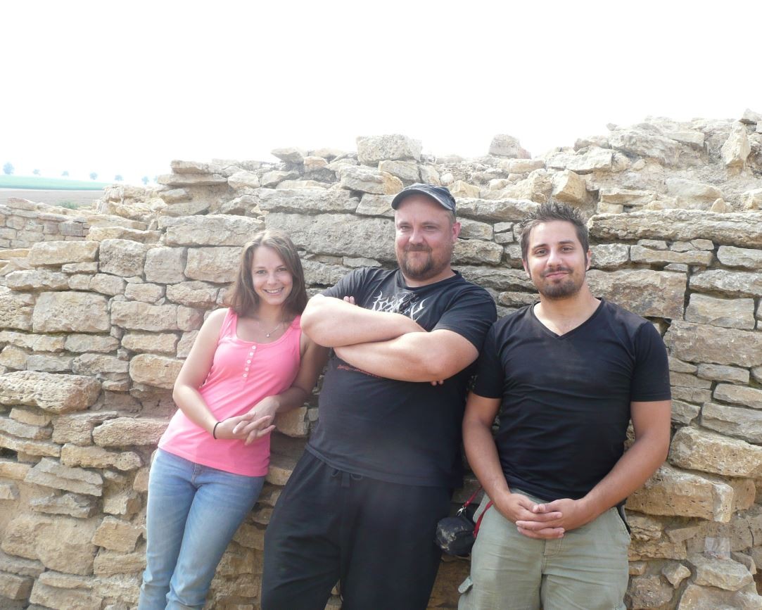 Grabungsleiter Kim Wegener (Mitte) und seine Praktikanten Sandra Maus (links) und Marcus Coesfeld (rechts) lächeln erschöpft in die Kamera.