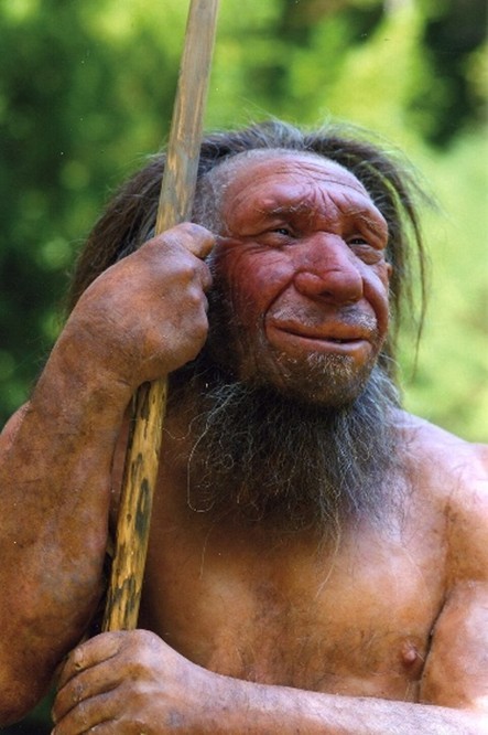 Nachgestellter Neandertaler mit ungepflegten und langen haaren, faltiges Gesicht Hat einen Speer in der Hand.