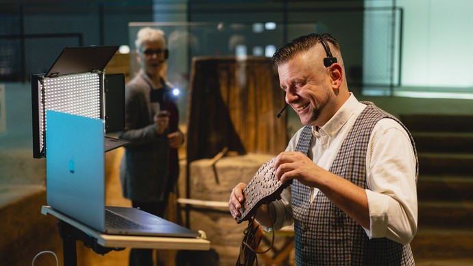 Guide Timo zeigt einen Römer-Schuh in die Kamera