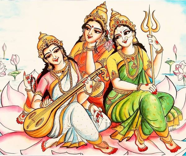 auf dem Bild sieht man (links) Saraswati, in der Mitte Lakshmi und rechts Parvati. Saraswati trägt ein indisches goldenes, weißes Kleid mit goldenen Schmuck. Sie hält eine Indische Gitarre. Sie ist Barfuß. Lakshimi trägt ein rot goldenes indisches Kleid mit goldenem Schmuck und sieht Saraswati beim Gitarre spielen zu, sie ist auch Barfuß. Parvati trägt ein gold grünes Kleid, wie die anderen trägt sie goldenen Schmuck und ist auch Barfuß. Sie hält einen Dreizack. Die drei Frauen sitzen auf einer Lotusblume, die in einem Fluss schwimmt. Im Hintergrund sieht man auch weiter Lotusblumen.