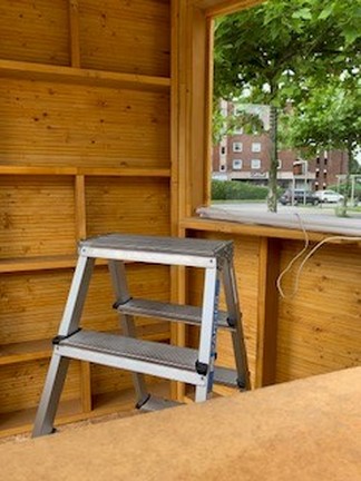 Der Kiosk wird auf dem Außengelände aufgebaut. Mit einer Leiter wurden Lampen installiert.