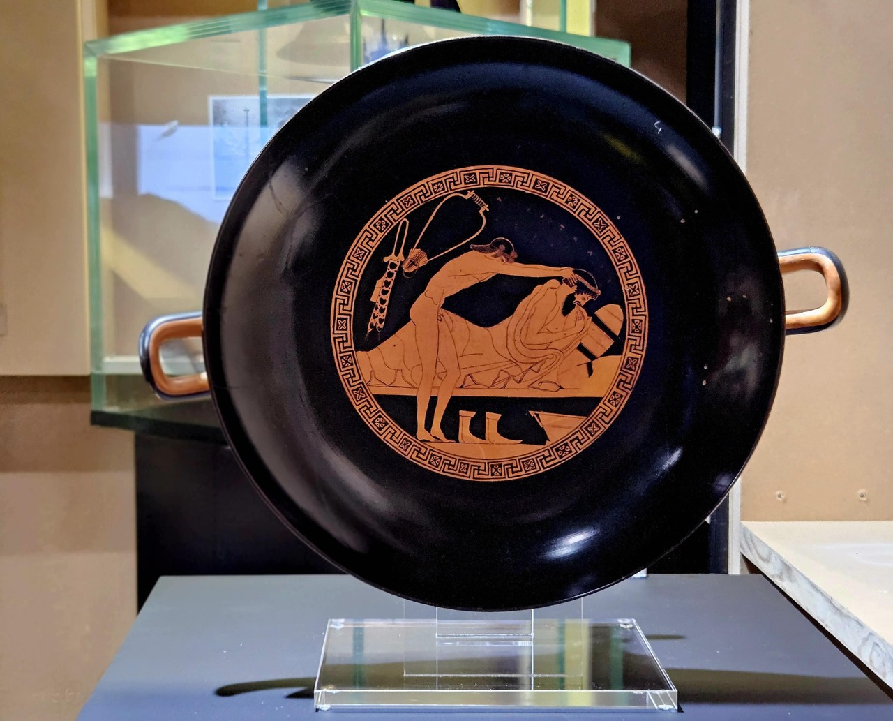 Zu sehen ist die Kylix, wie sie auf einem Sockel in der Sonderausstellung „Mahlzeit! Wie Essen uns verbindet“ ausgestellt wird.