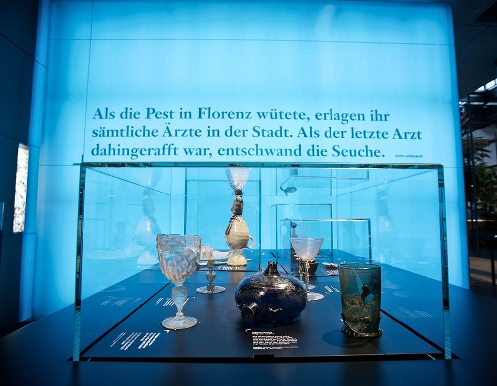 Vitrine mit verschiedenen Gläsern vor dem Stadtkubus im Hintergrund (Bild: LWL/P. Jülich)