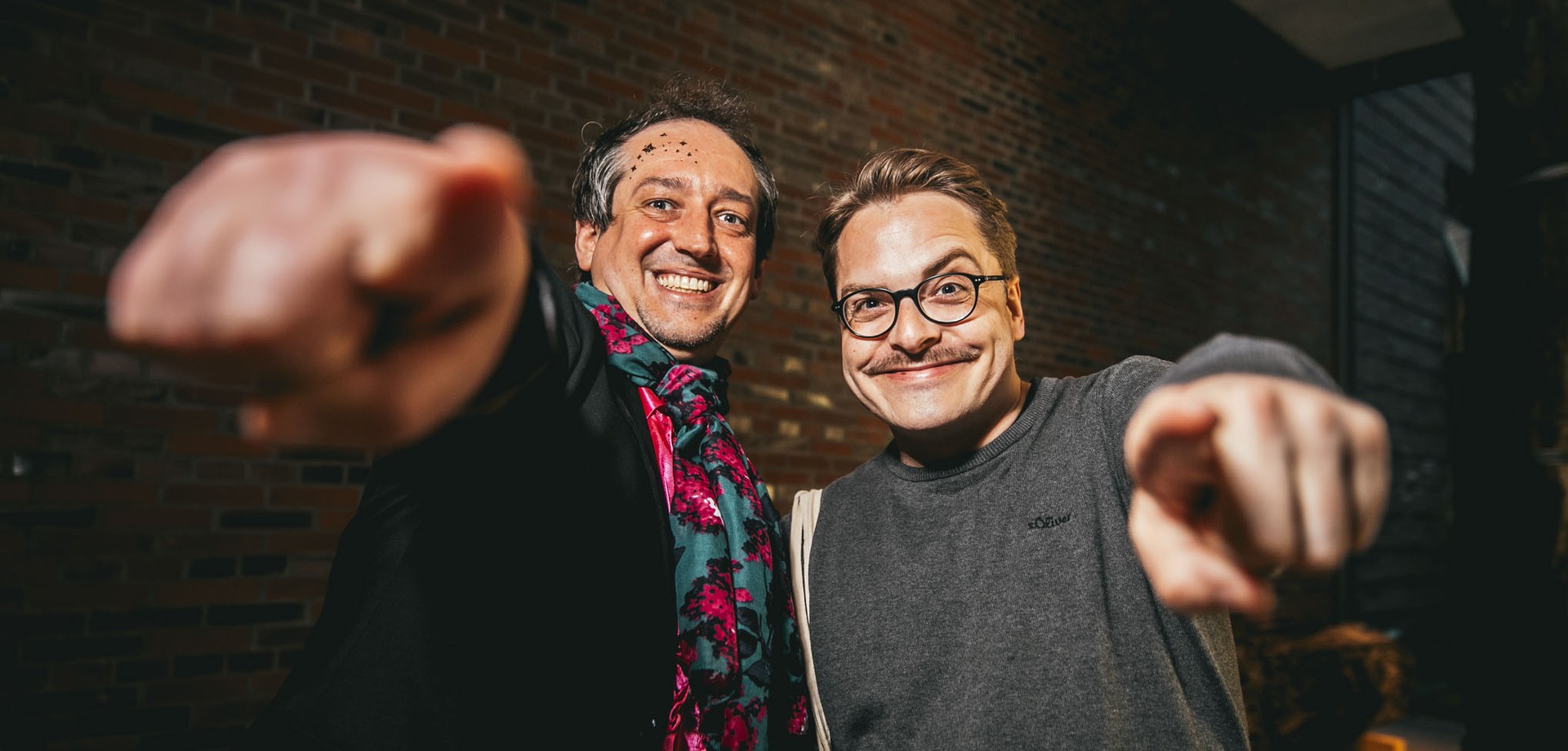 Besuchender und Guide gucken in die Kamera