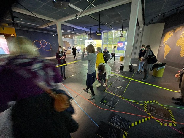 Einige Menschen bewegen sich durch einen Ausstellungsraum und gestalten diesen selbst durch Wege. Einige Menschen bewegen sich durch einen Ausstellungsraum und gestalten diesen selbst durch Wege.