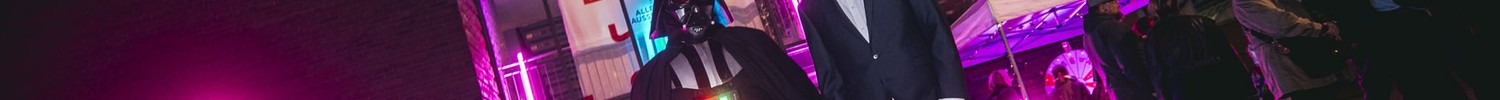 Beleuchteter Eingang des Museums mit zwei Besuchenden in Cosplay
