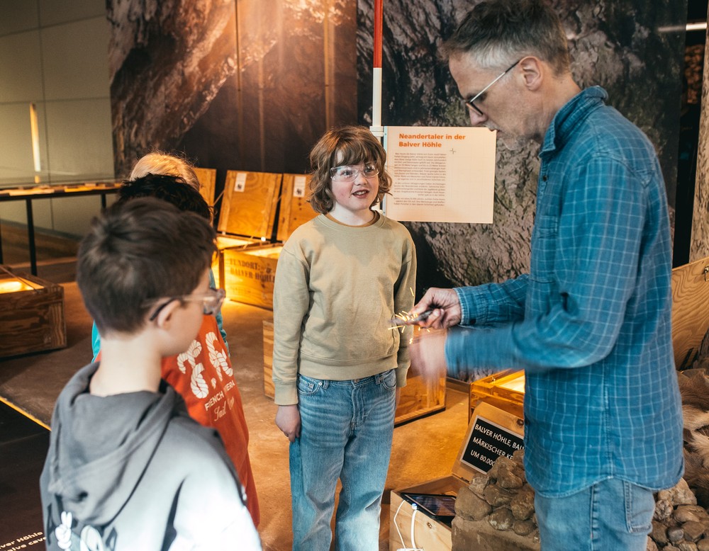 Wie wird Feuer gemacht? Ein Museumspädagoge zeigt es den Kindern.