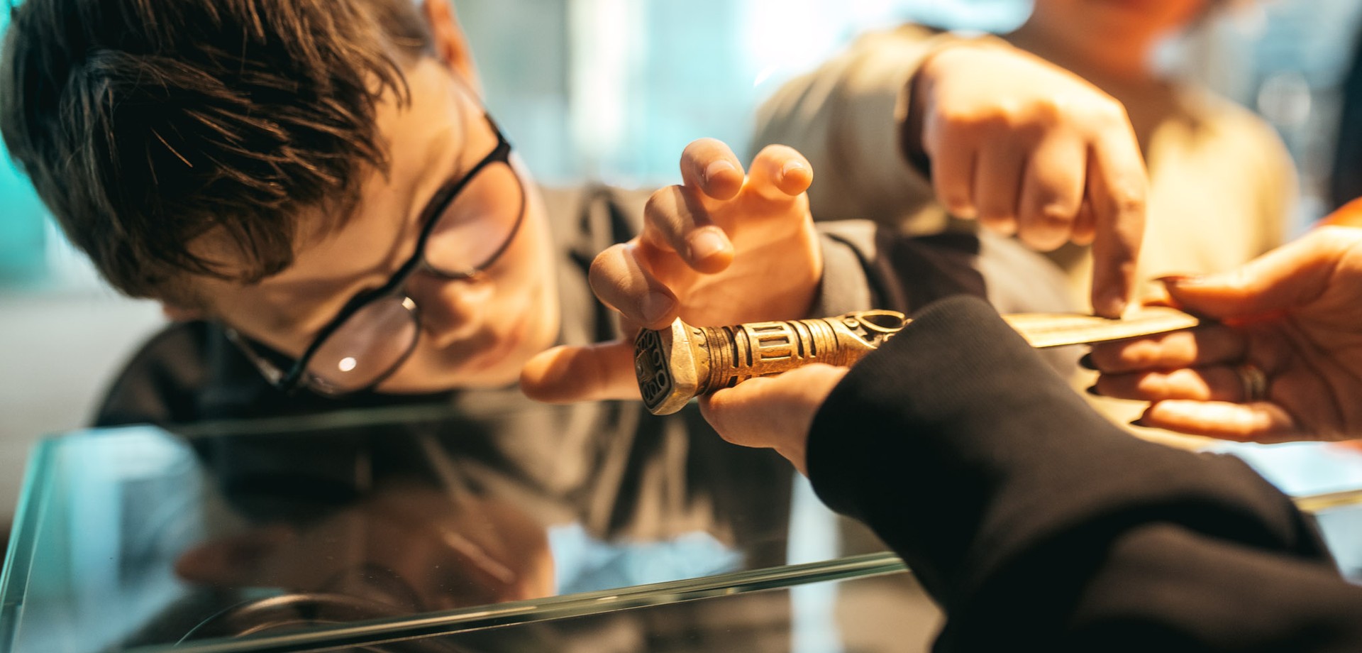 Ein Schüler erkundet einen Bronzedolch mit den Fingern.