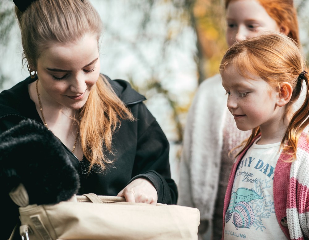 Zwei Mädchen warten gespannt, was in einer Tasche ist